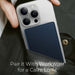 Blessing's navy blue magnetic wireless charging power bank attached to a silver smartphone, tucked into a dark green jacket pocket.