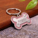 Blessing Sells personalized pink glitter bone-shaped pet ID tag with 'Angela' engraved and a paw print.