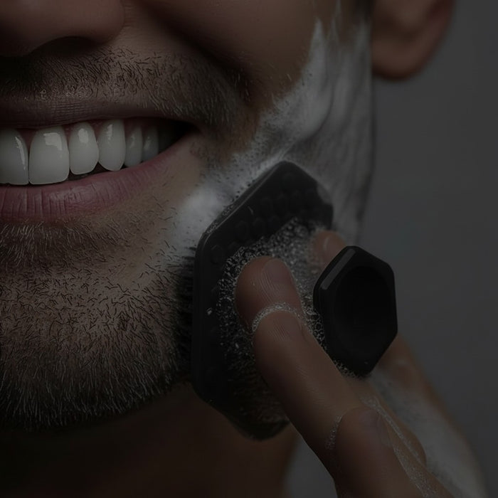 Blessing Sells dark grey silicone face scrubber with textured grip, used for exfoliation and cleansing.