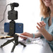 Blessing Sells smartphone vlogging kit with microphone, LED light, and tripod. A woman is blurred in the background.