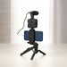 Blessing Sells smartphone vlogging kit with microphone, LED light, and mini tripod, holding a blue iPhone.